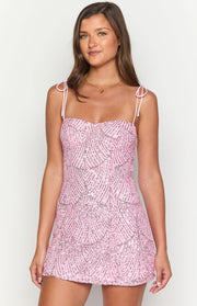 Pink sequin mini dress featuring a sweetheart neckline, tie-shoulder straps, and a detailed sequin pattern