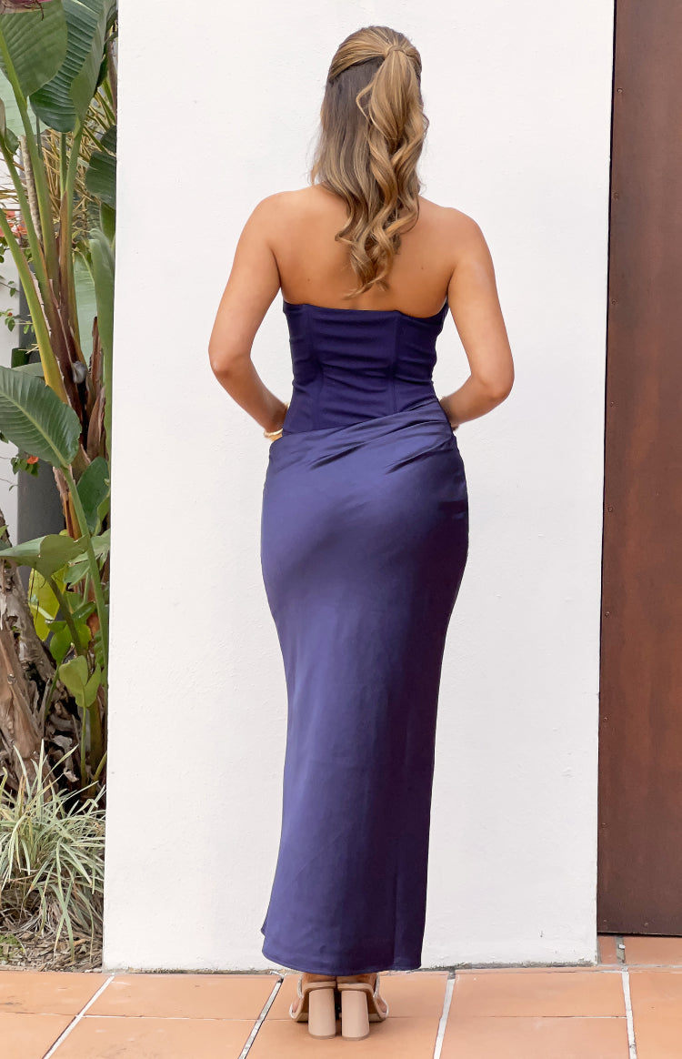 Rear view of a navy strapless maxi dress with a structured bodice and draped satin skirt