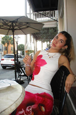 Upper portion of a fitted white maxi skirt with a large vibrant pink orchid print