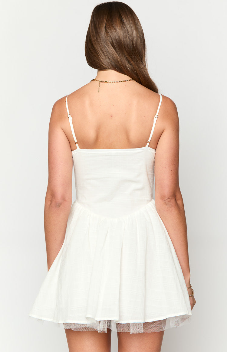 Rear view of a white mini dress with thin adjustable straps, a square back, and a flared skirt with a tulle underskirt