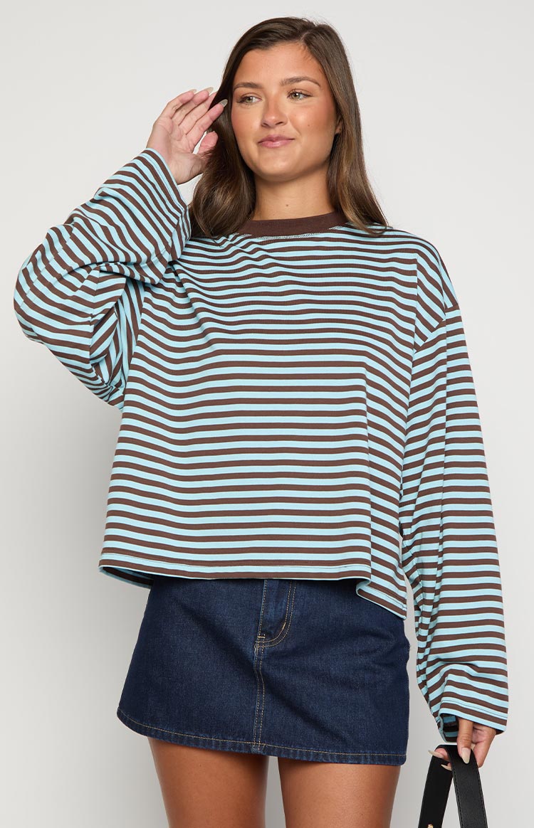 Front view of a dark wash denim mini skirt with yellow contrast stitching and a curved hem