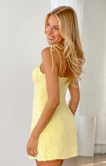 Side view of a yellow sequin mini dress with tie-up spaghetti straps