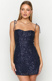 Close-up of the navy sequin mini dress showing the geometric sequin pattern, sweetheart neckline, and tie straps