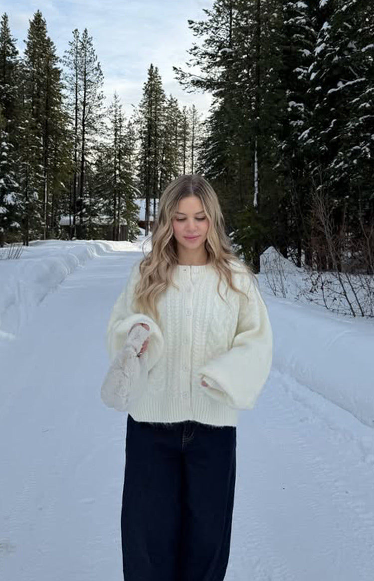 Relaxed fit cream cable knit cardigan with wide long sleeves and a button-front closure