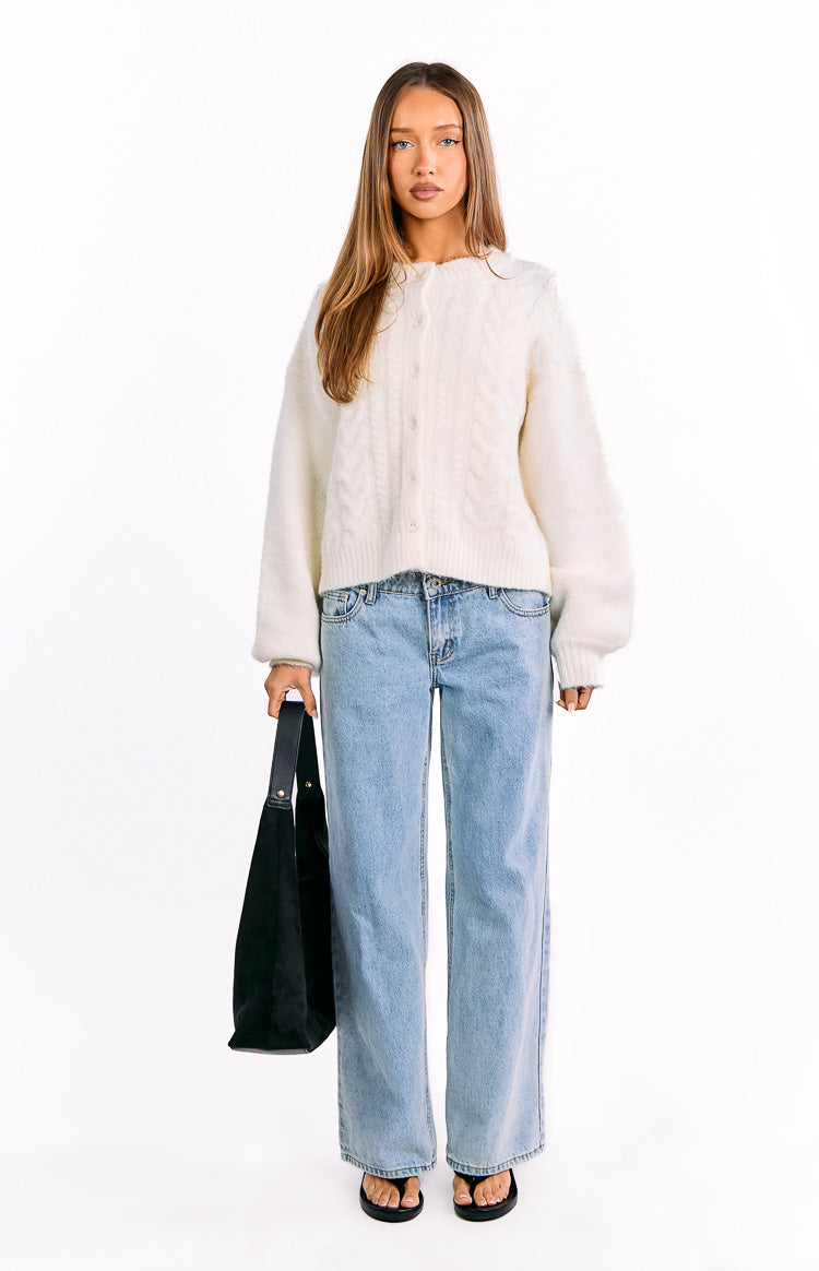 Cream cable knit cardigan with a round neck, button-front, long sleeves, and a relaxed cropped fit