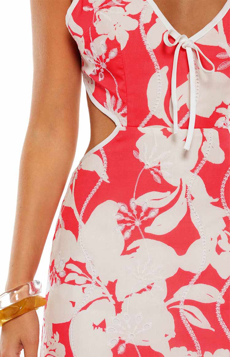 Close-up of the red and white floral maxi dress with white embroidered pattern, side cut-out, and tie-front detail