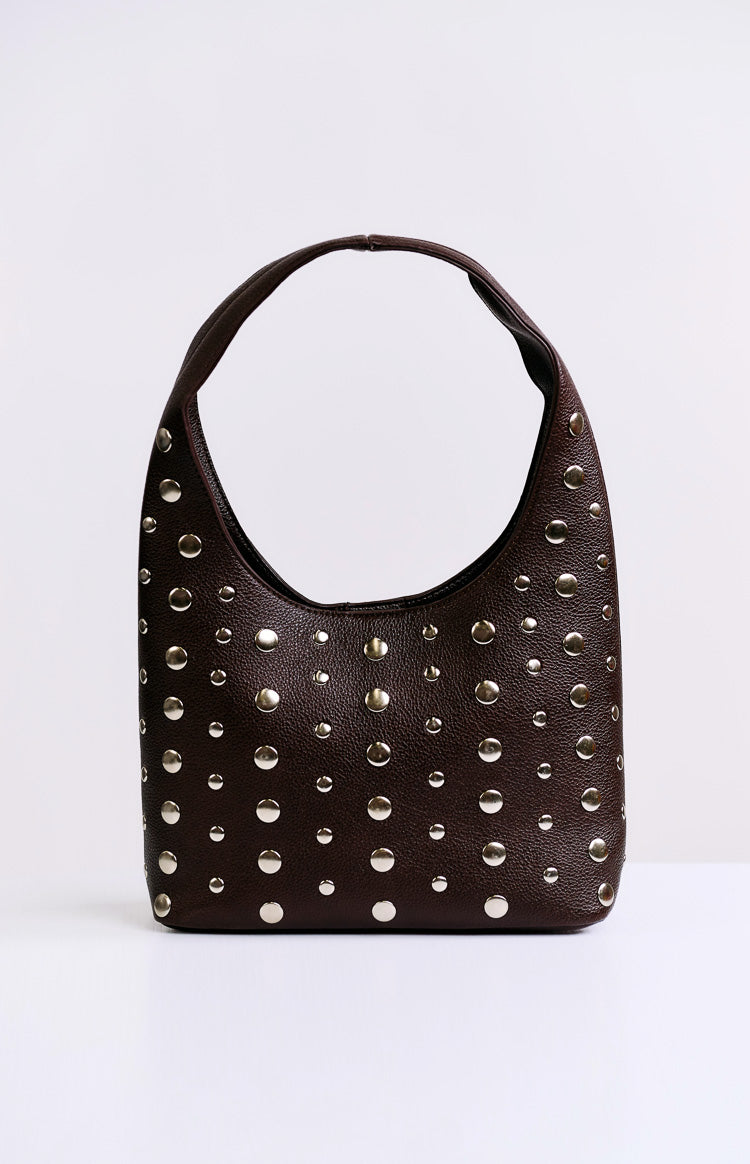 A brown leather-like hobo bag decorated with numerous silver studs of varying sizes across the front, with a single strap.