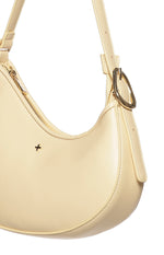 Close-up of the cinder yellow shoulder bag showing the gold zipper closure, plus logo, and adjustable strap buckle