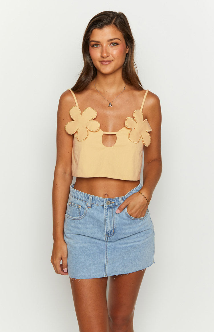 Front view of a petal yellow crop top with flower appliques and a central cut-out detail