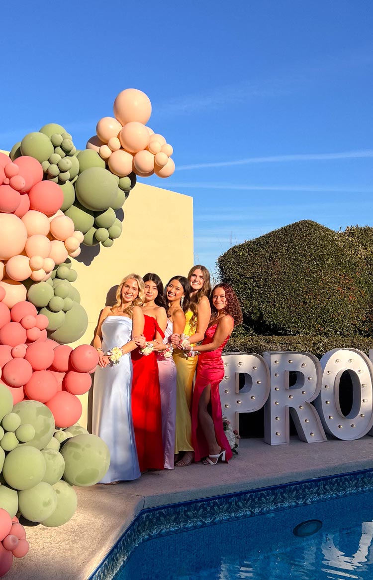 Fitted pink satin strapless maxi dress with a high side slit, shown outdoors