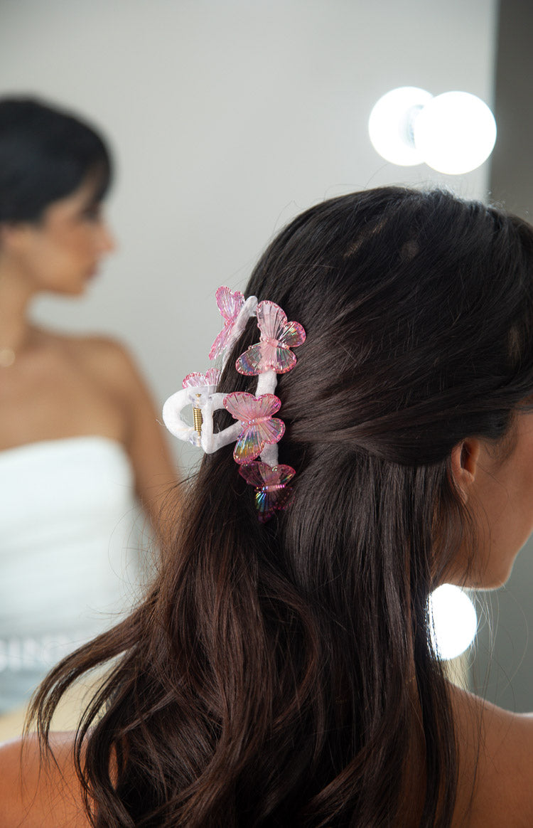 Side view of the white claw clip with pink iridescent butterflies, showing their ribbed texture