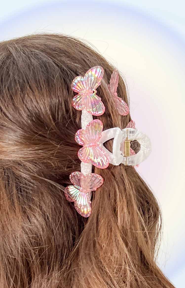 Side view of the pink iridescent butterfly claw clip with multiple butterflies and clear claw mechanism