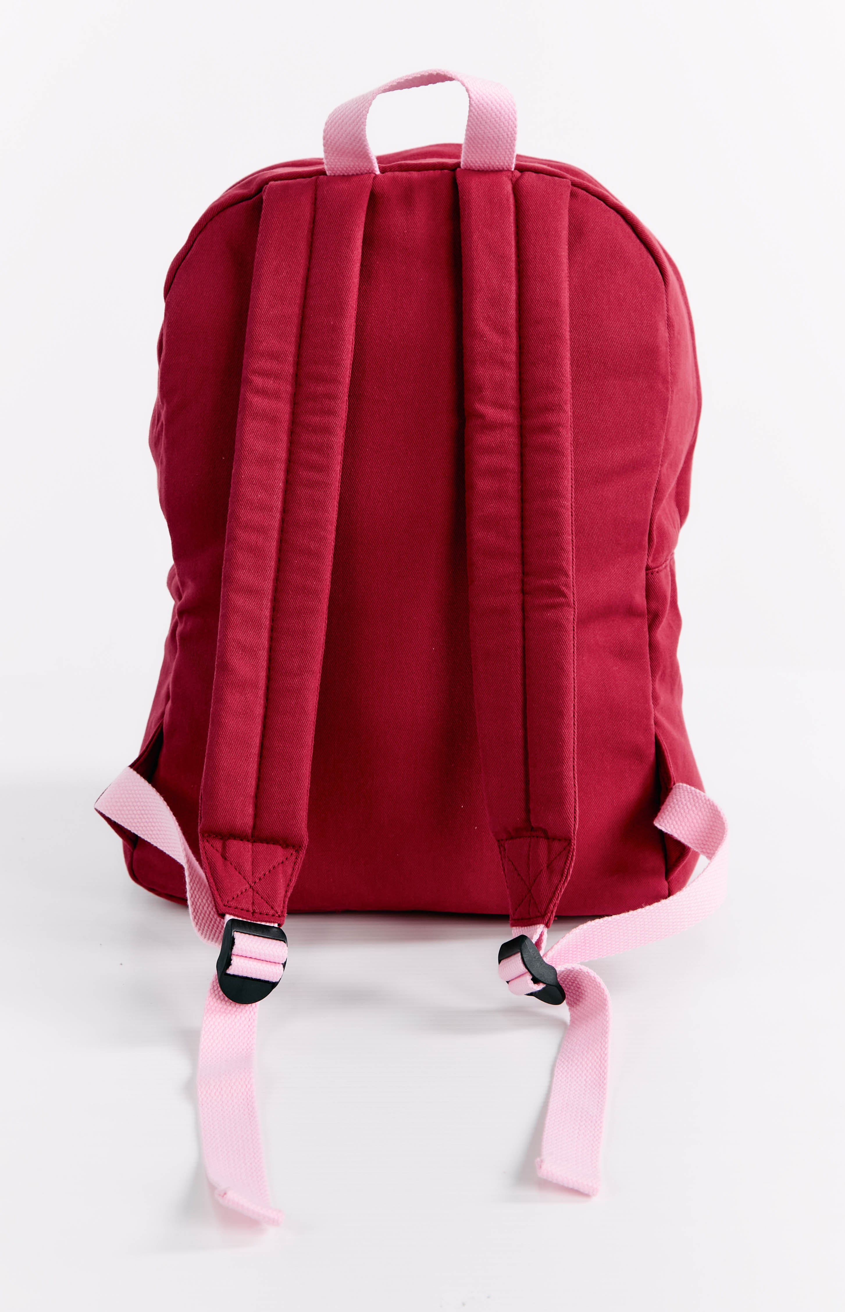 Rear view of a burgundy backpack with pink adjustable shoulder straps and top handle