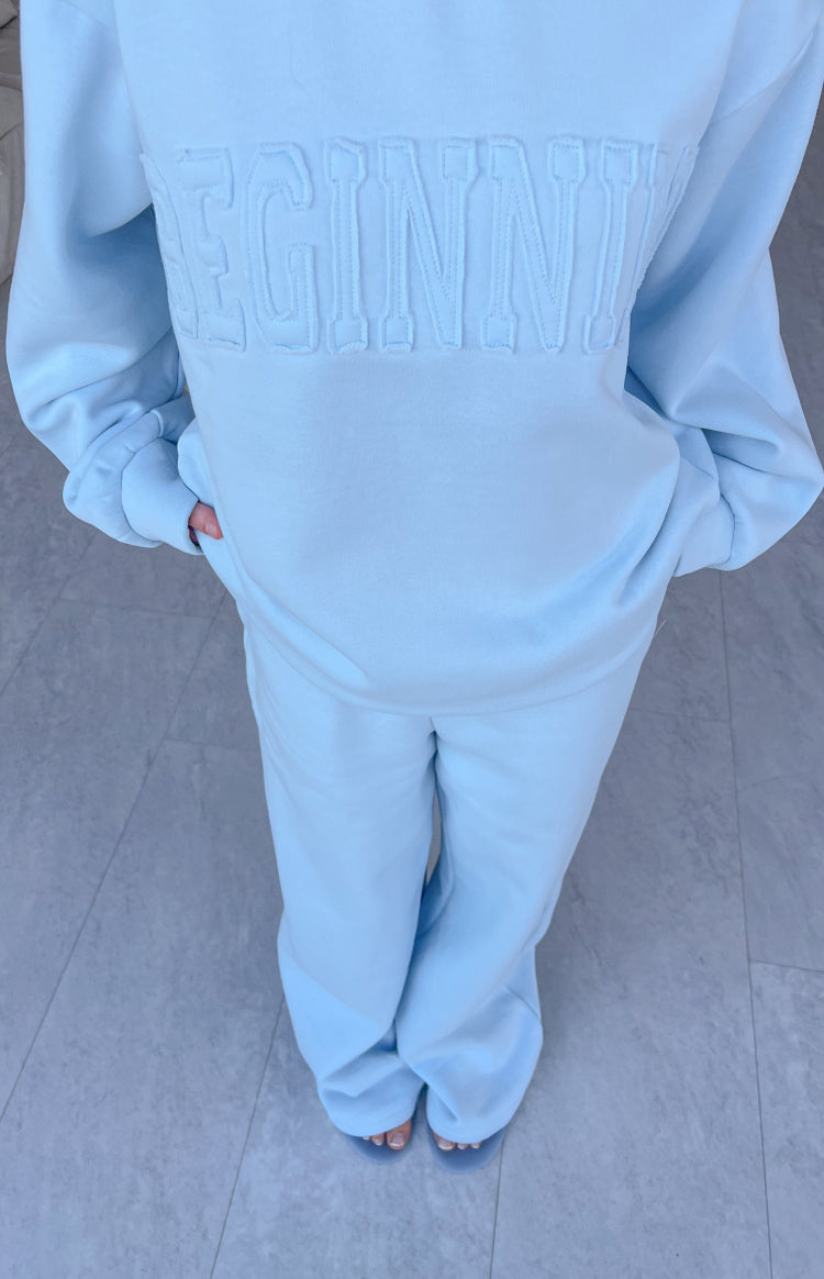 Light blue slouch fit trackpants with wide leg opening, paired with a matching sweatshirt featuring embossed lettering