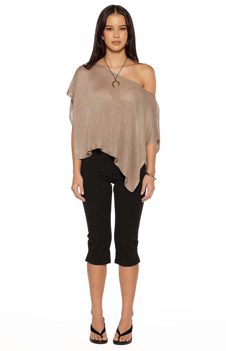 Shimmering gold metallic knit poncho with an off-shoulder neckline and a draped, asymmetrical hem