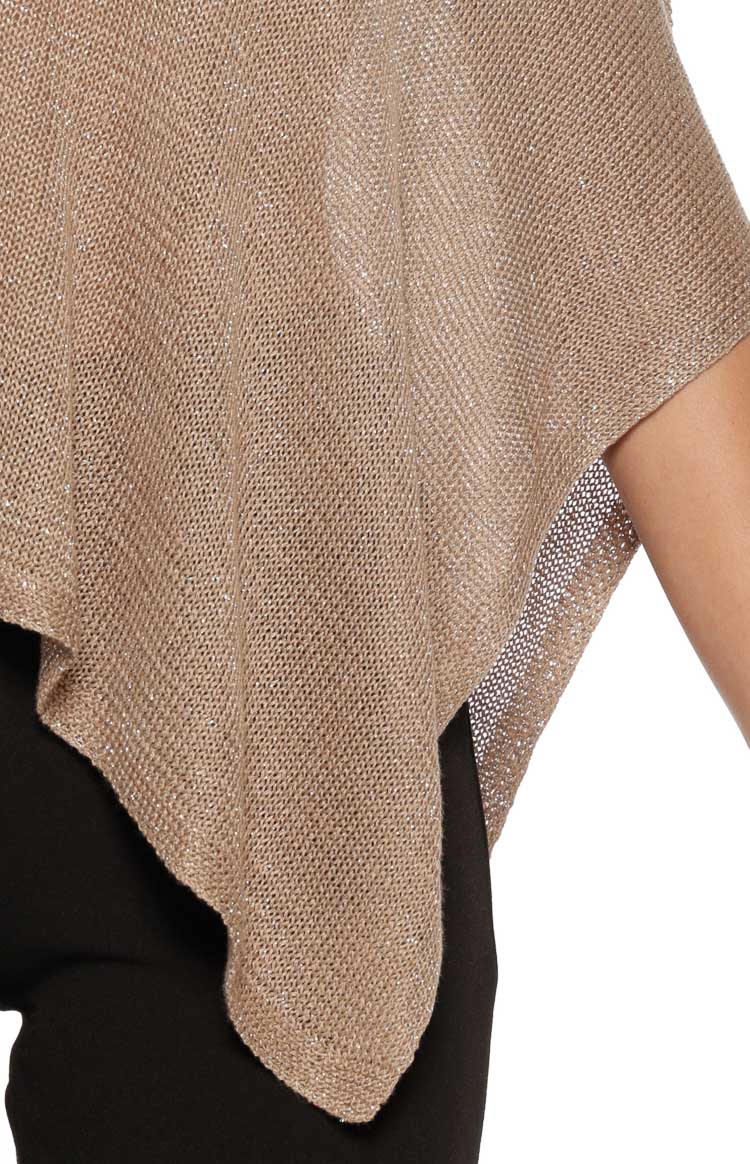 Side view of the loose, flowing drape and metallic shimmer of the beige knit poncho