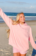 Front view of a pink relaxed fit hoodie featuring embossed 'Beginning' text on the chest