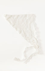 Flat lay of a white lace triangle scarf with delicate floral pattern and scalloped edges, showing tie straps