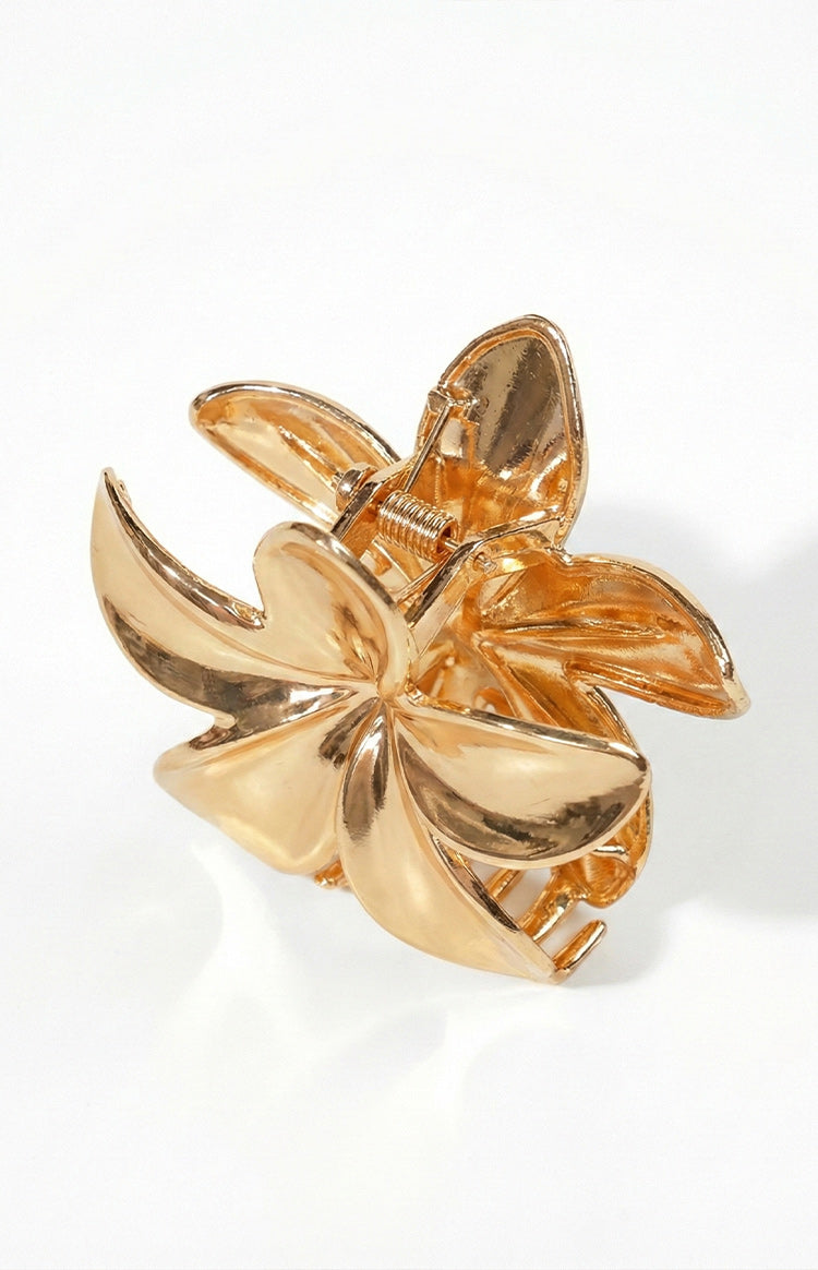 Angled side view of the gold metal flower claw clip, showing the spring and layered petals