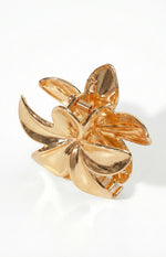 Angled side view of the gold metal flower claw clip, showing the spring and layered petals