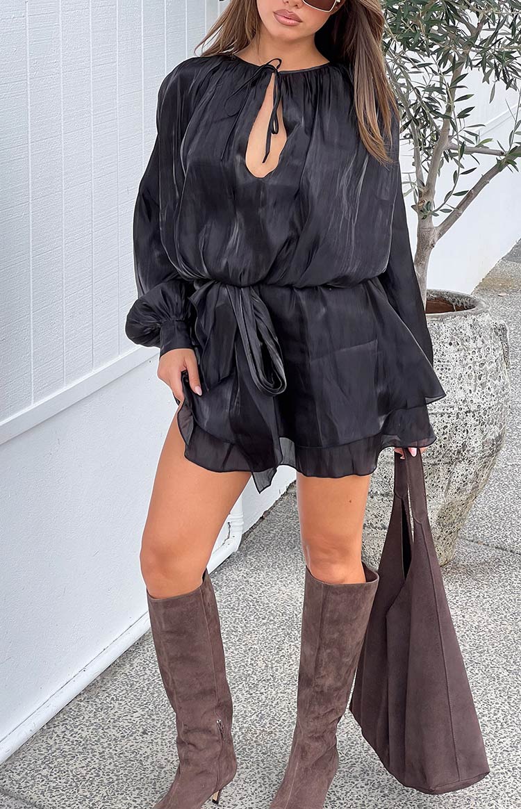 Black satin mini dress with a keyhole tie neckline, blouson long sleeves, cinched tie waist, and tiered ruffle hem