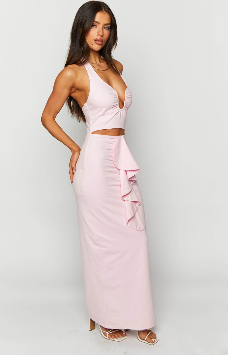 Side view of a pink maxi dress with waist cutouts and a cascading ruffle detail on the skirt