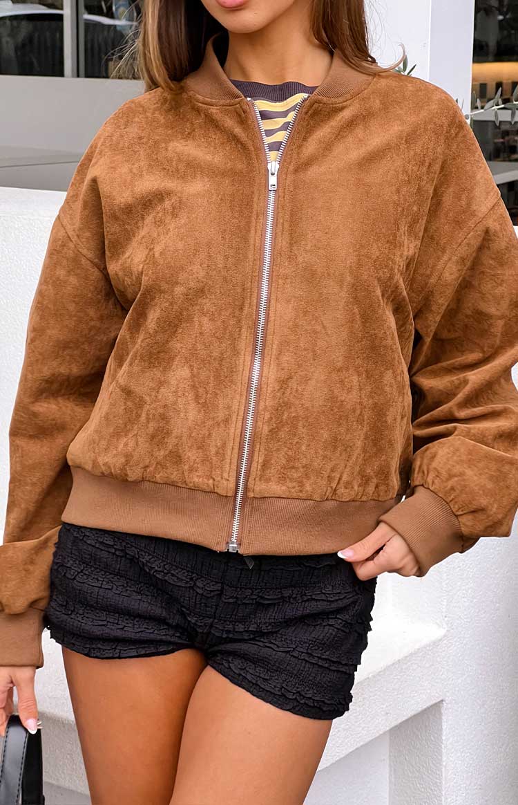 Close-up of the tan suedette bomber jacket showing the silver front zipper and ribbed hem and cuffs