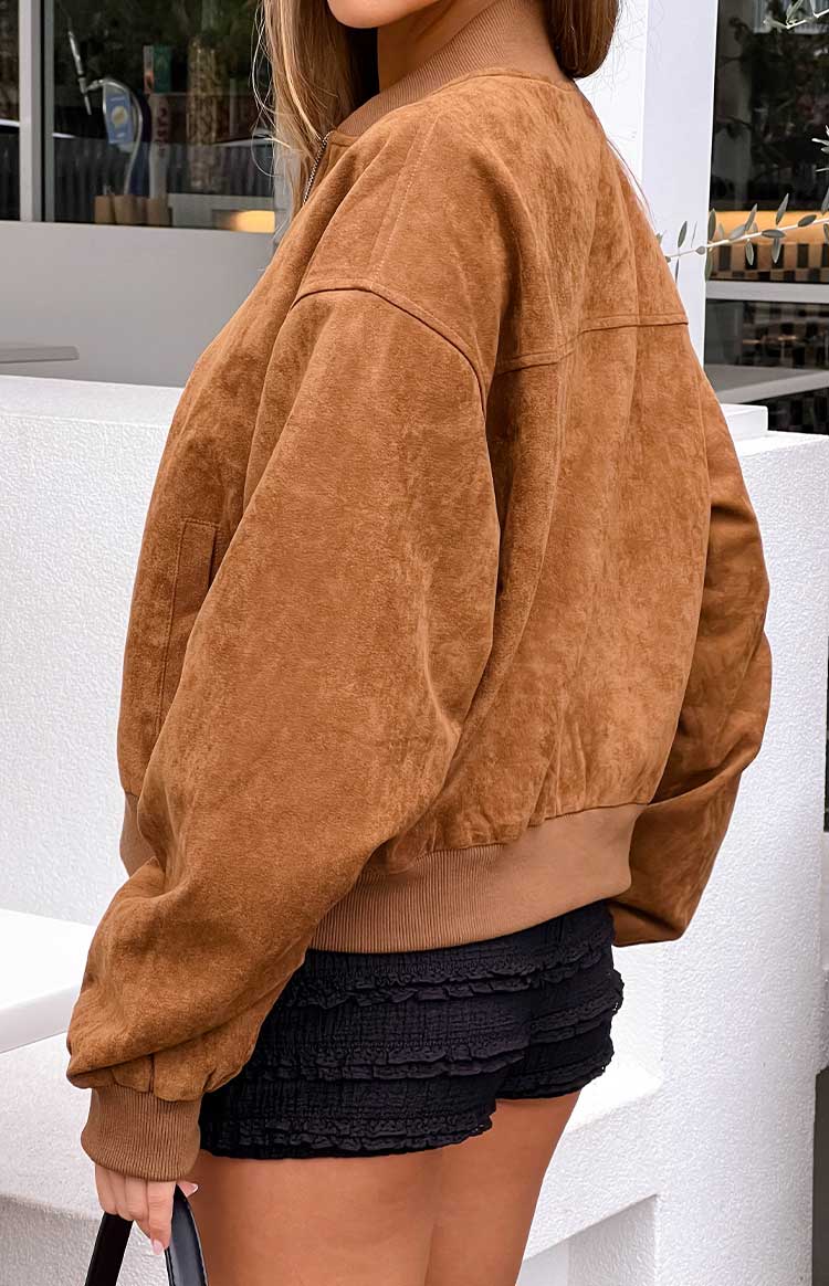 Side view of the oversized brown suedette bomber jacket with dropped shoulders, textured fabric, and ribbed cuffs and hem