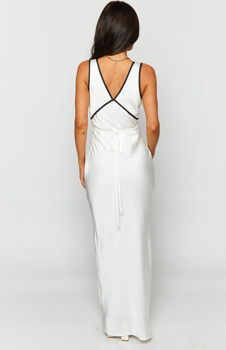 Rear view of a white maxi dress with black contrast trim on the deep V-neckline and a self-tie detail at the waist