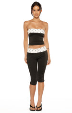 Black capris with a white polka dot waistband and small slits at the hem