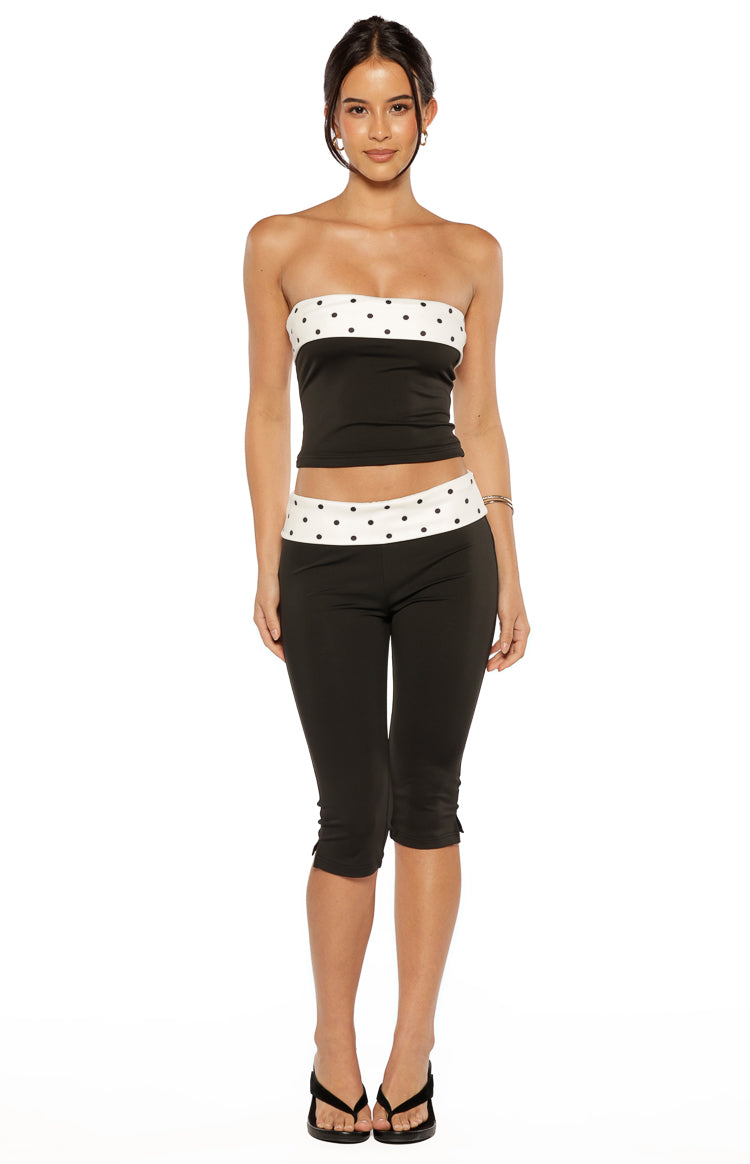 Black capris with a white polka dot waistband and small slits at the hem