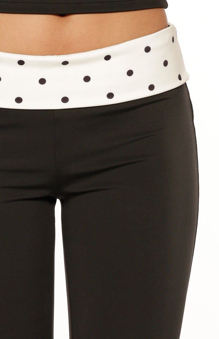 Close-up of the wide white waistband with black polka dots and the smooth black fabric of the capris