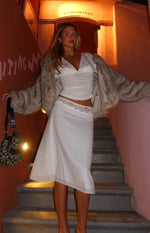White slip midi skirt with delicate lace trim at the waist and a flowy hem