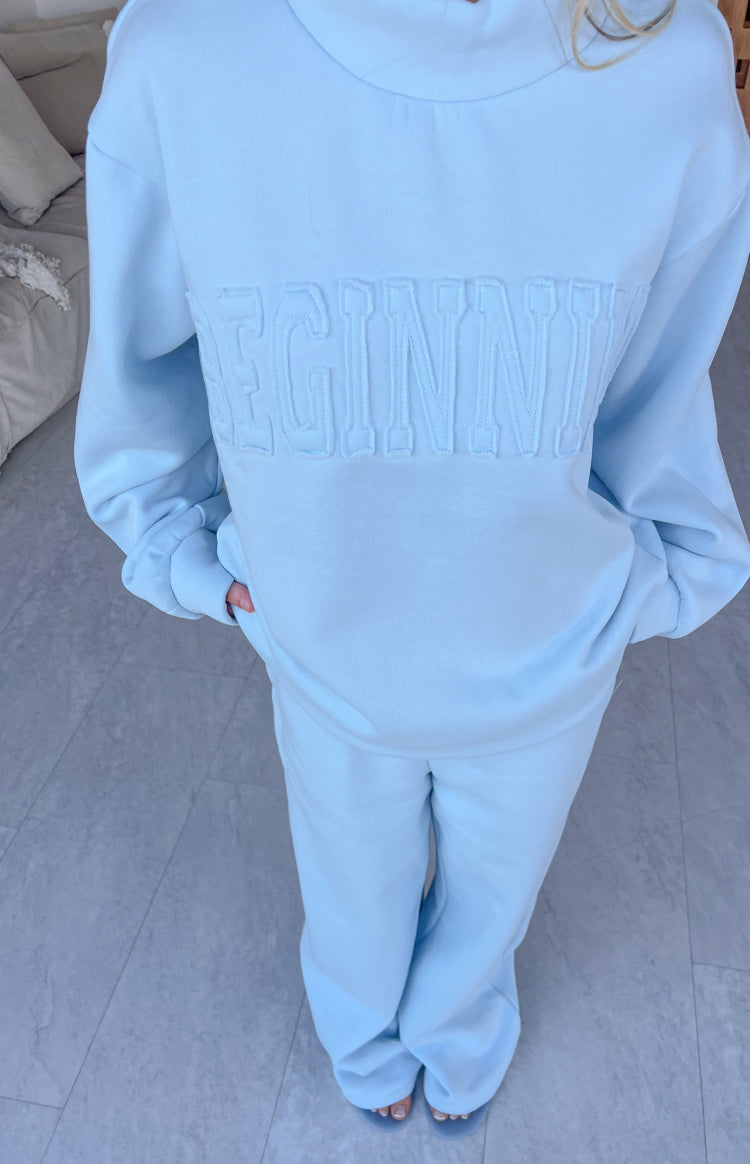 Textured applique lettering on a light blue mock neck sweater with a relaxed fit