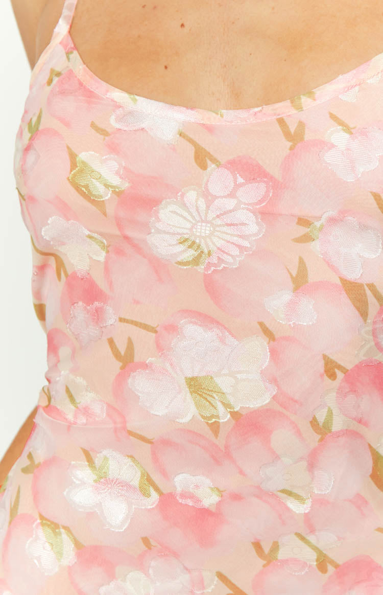 Close-up of the sheer pink floral chiffon maxi dress fabric with woven white and gold flower details