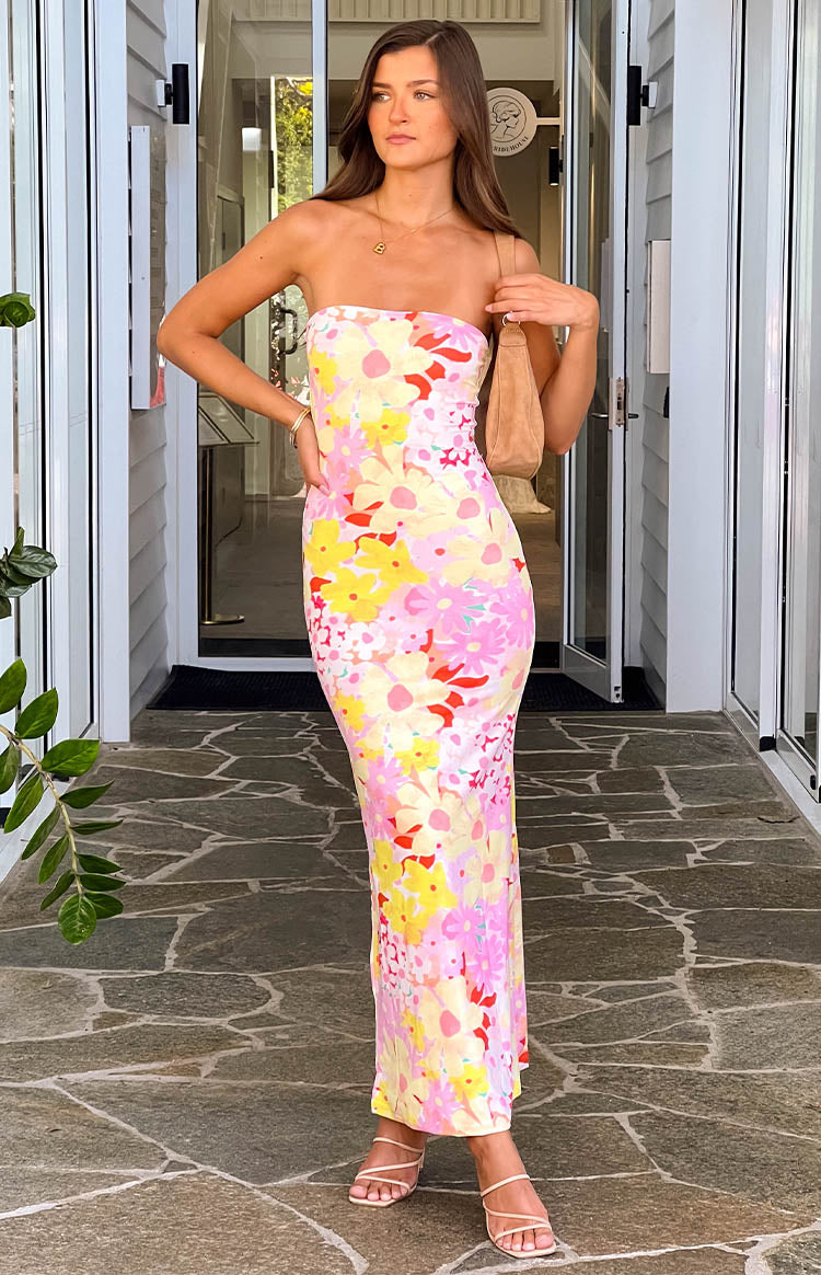 Full front view of a strapless maxi dress with a vibrant yellow, pink, and red floral print and a bodycon fit