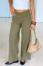 Green straight leg pants with a unique V-shaped crossover waistband and relaxed fit
