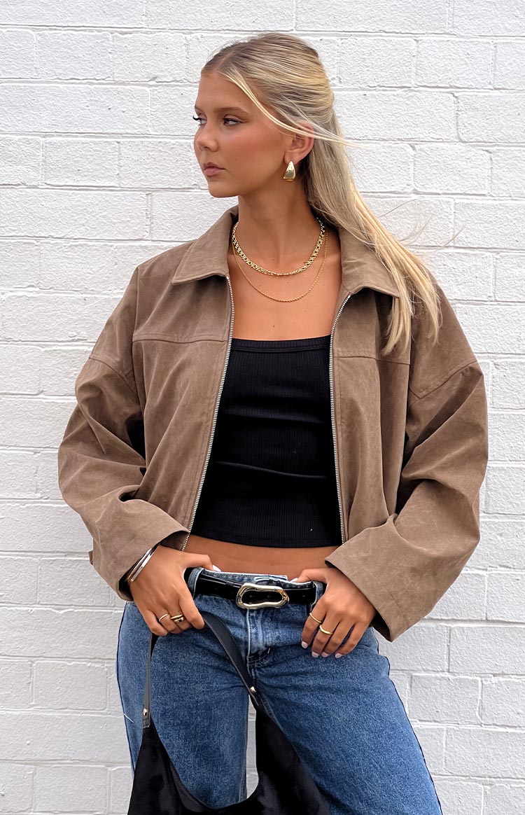 Front view of a cropped brown suedette bomber jacket with a collared neckline and open zipper