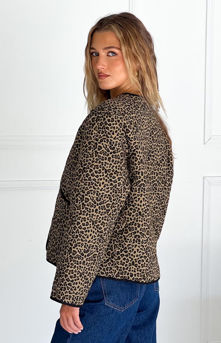 Side view of a leopard print quilted jacket with black trim and a relaxed fit