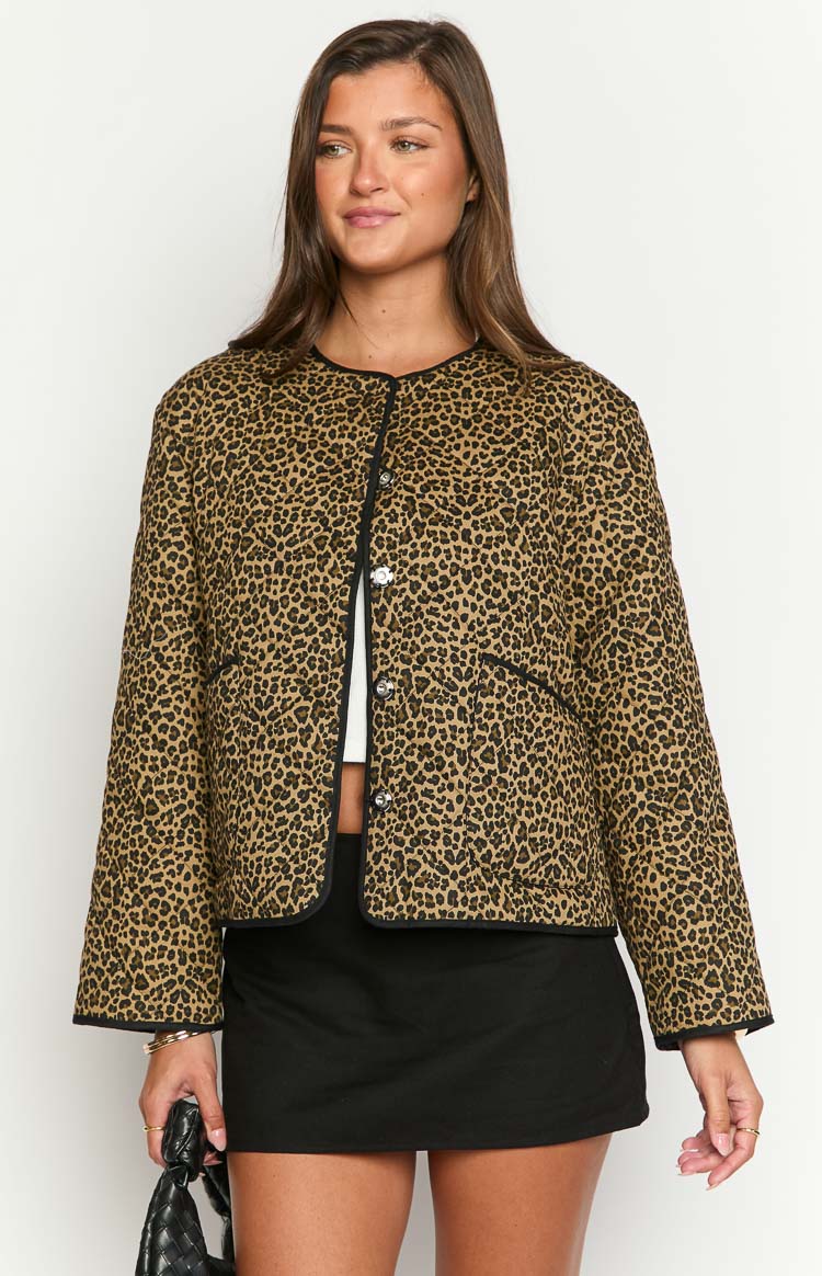 Leopard print quilted jacket featuring black piping along the edges, a round neckline, and silver button-front