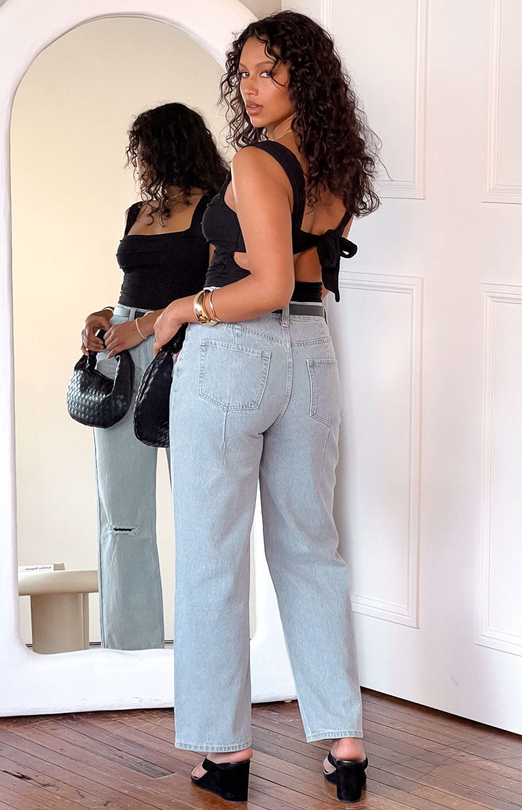 High-waisted light blue wash wide leg jeans featuring visible back pockets and a full length