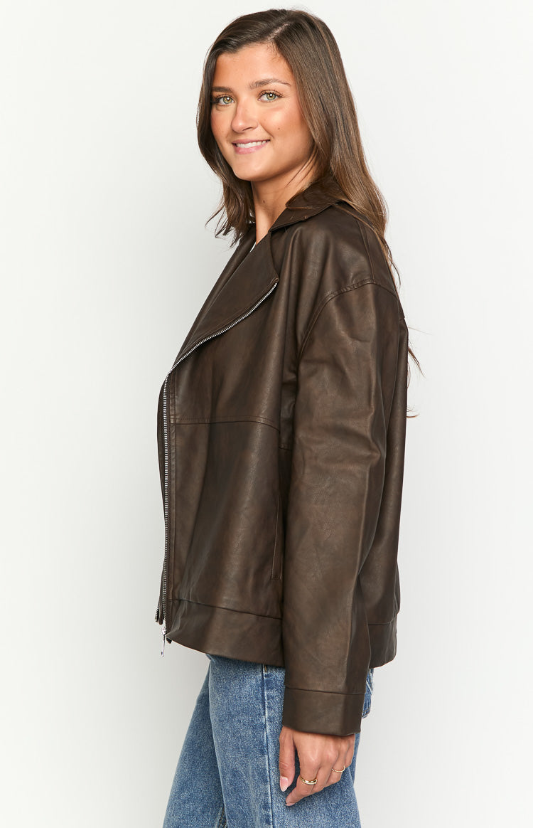Side view of a chocolate brown oversized PU biker jacket with an asymmetrical zipper and wide lapel
