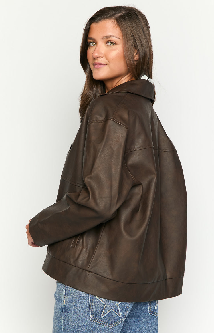 Side view of an oversized chocolate brown PU biker jacket with a wide collar and a rounded bottom hem