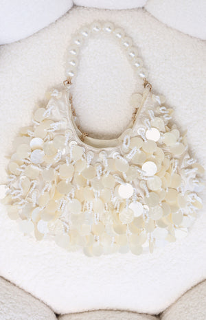 Cream handbag featuring a pearl beaded handle and layered mother-of-pearl disc and seed bead embellishments