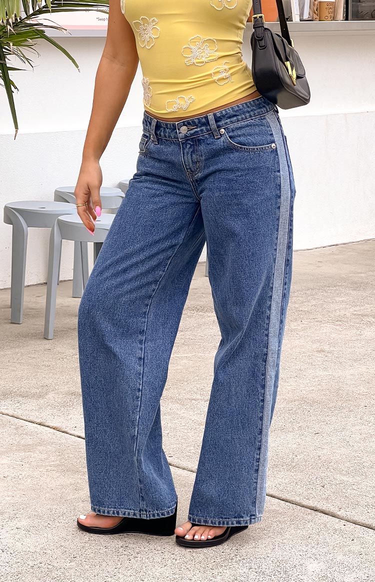 Mid wash denim low rise jeans with a wide leg and a lighter contrast stripe down the side seam