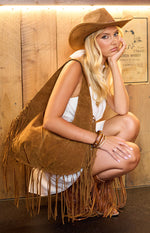 Tan suedette shoulder bag with long fringe, showcasing the soft fabric and flowing drape