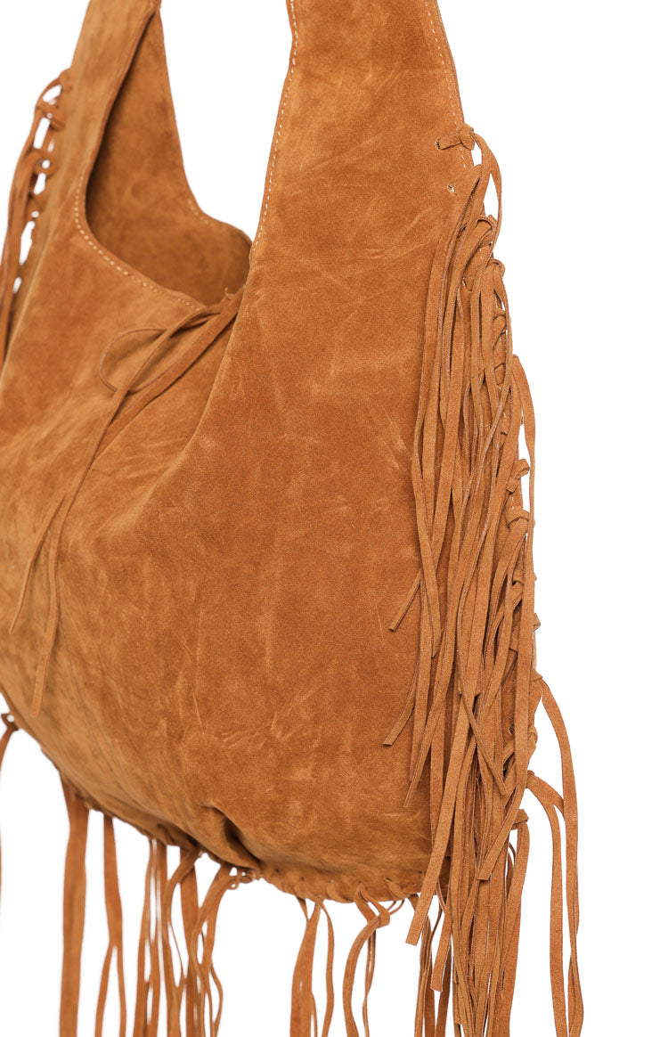 Close-up showing the tan suedette texture, long fringe detail on the side, and the top tie closure