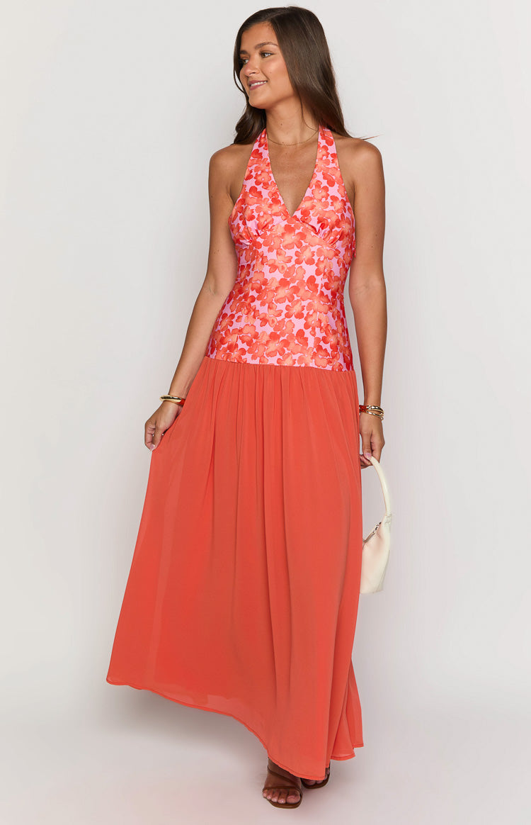 Front view of an orange floral maxi dress featuring a pink floral halter V-neck bodice and a solid orange maxi skirt