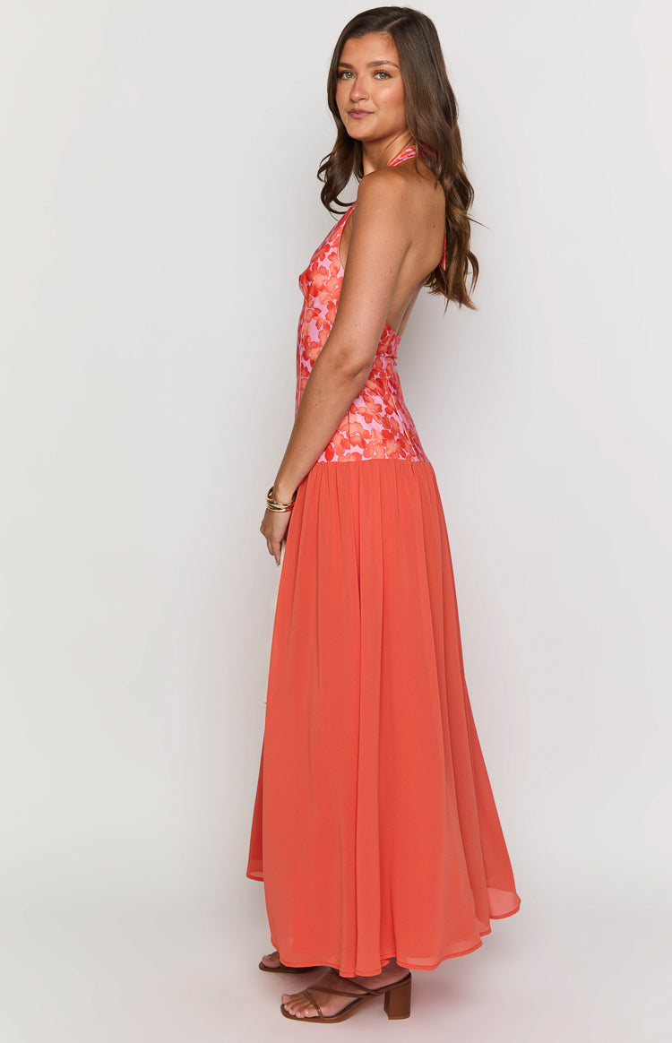Side view of an orange floral maxi dress showing the halter neck, fitted floral bodice, and full flowing skirt
