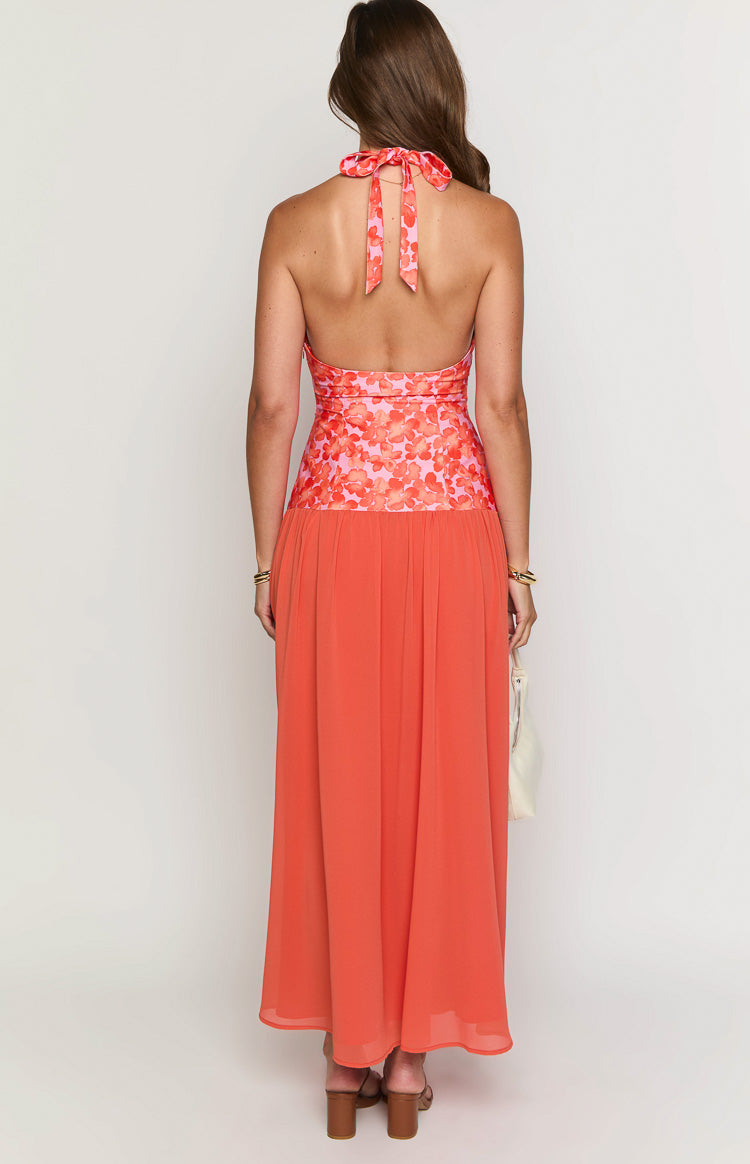 Rear view of an orange floral maxi dress showing the halter neck tie and open back with a pleated waist